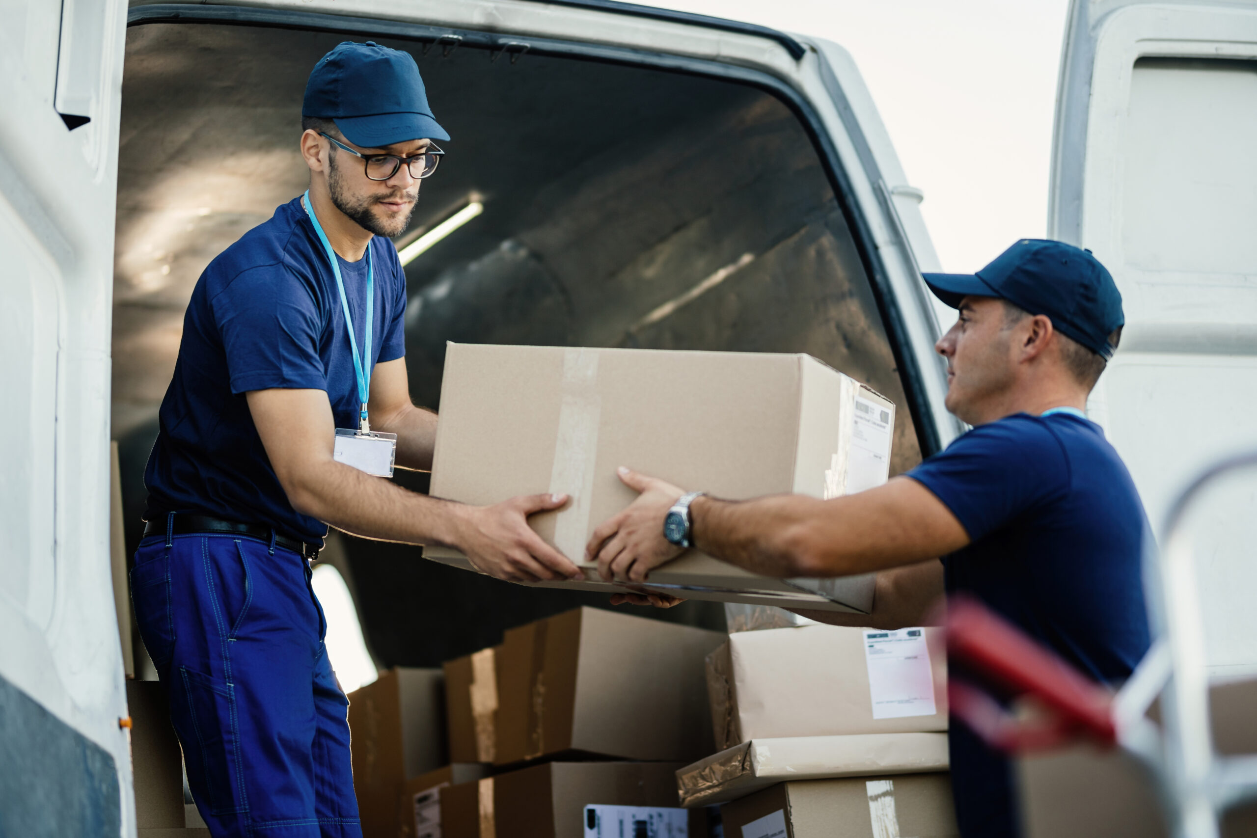 delivery men loading carboard boxes van while getting ready shipment scaled